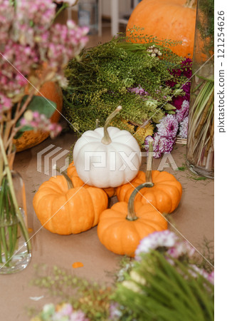 Flower arrangement in a pumpkin, autumn interior decor. Creating handmade autumn decor. Flower arrangement in a pumpkin, autumn interior decor. Creating handmade autumn decor. 121254626