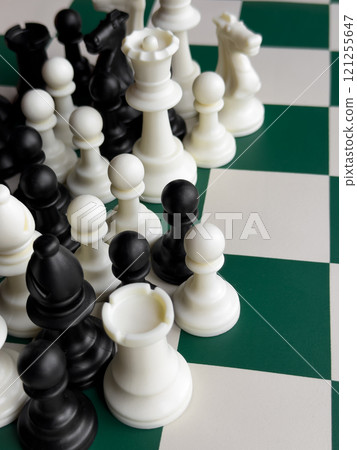Black and white chess pieces on board reflecting strategy and competition 121255647