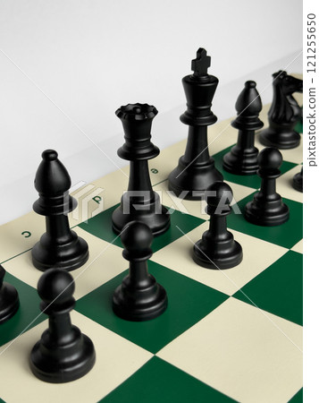 Close up of black chess pieces on green and white chessboard Close up of black chess pieces on green and white chessboard 121255650