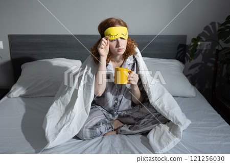 Enjoying a Cozy Morning Routine with Delicious Coffee and a Comfortable Sleep Mask 121256030