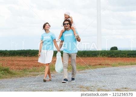 Caucasian family in vacation activity. Happy cheerful caucasian white family with daughter are walking and relaxing together in the daytime in nature with windmill towers in background. Caucasian family in vacation activity. Happy cheerful caucasian white family with daughter are walking and relaxing together in the daytime in nature with windmill towers in background. 121256570