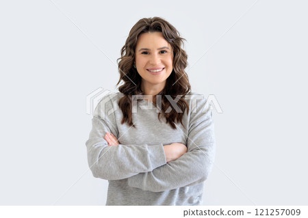 Beautiful European woman in gray knitted suit smiles and holds her hands crosswise.  121257009
