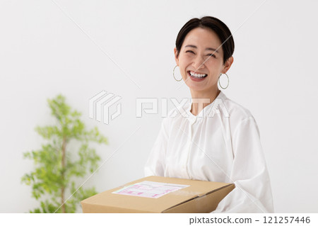 Image of a woman carrying luggage (stock photo) Image of a woman carrying luggage (stock photo) 121257446
