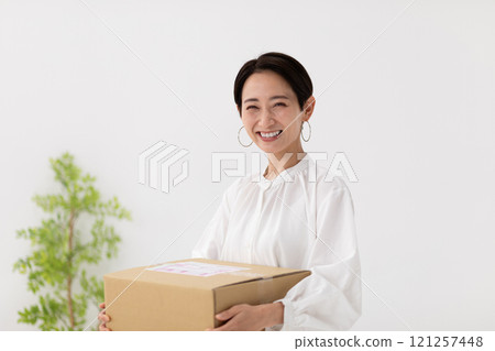 Image of a woman carrying luggage (stock photo) Image of a woman carrying luggage (stock photo) 121257448