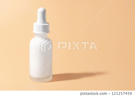 A frosted white dropper bottle on a pastel blue background A frosted white dropper bottle on a pastel blue background 121257459