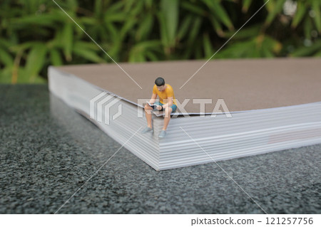 Figures Reading and Relaxing on a Giant Book 121257756