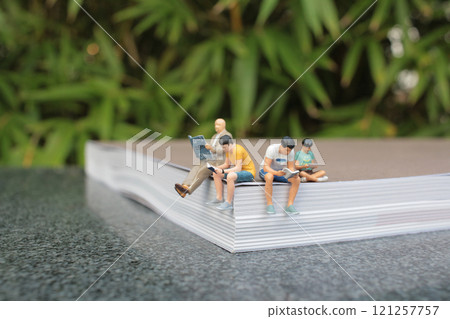 Figures Reading and Relaxing on a Giant Book 121257757