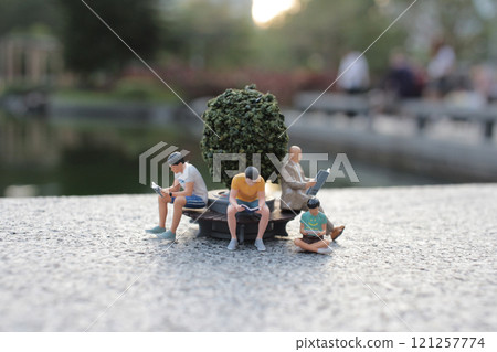 Miniature People Relaxing in Scenic Park Setting Miniature People Relaxing in Scenic Park Setting 121257774