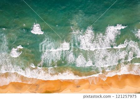 Top view beach with waves crashing on sandy shore,Beautiful waves sea surface in summer seascape background,Amazing beach colorful water background 121257975