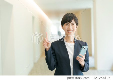 穿著西裝的女人站著他的食指 穿著西裝的女人站著他的食指 121258106