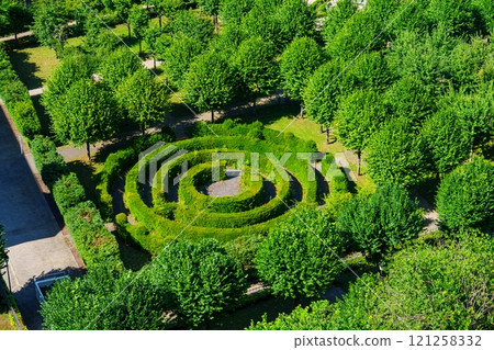 Aerial View of a Lush Green Park with a Circular Maze in Luxembourg Surrounded by Tall Trees 121258332