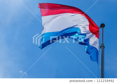 Waving flag of Luxembourg in front of blue sky on a sunny day 121258492