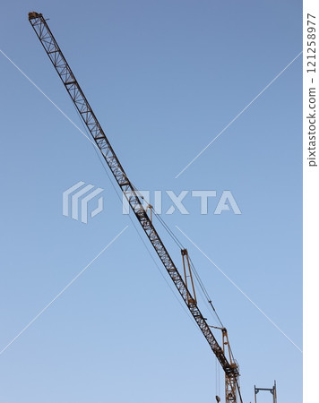A crane is seen in the sky above a blue sky 121258977