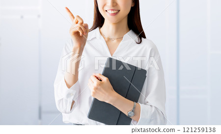 A smiling woman/businesswoman giving directions while holding a tablet A smiling woman/businesswoman giving directions while holding a tablet 121259138