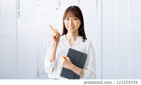 A smiling woman/businesswoman giving directions while holding a tablet A smiling woman/businesswoman giving directions while holding a tablet 121259139