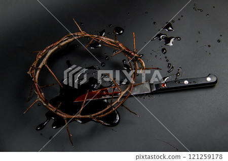 A crown of thorns with blood and knife on a dark background. Conceptual photo to use in the design. A wreath of branches with thorns with blood 121259178