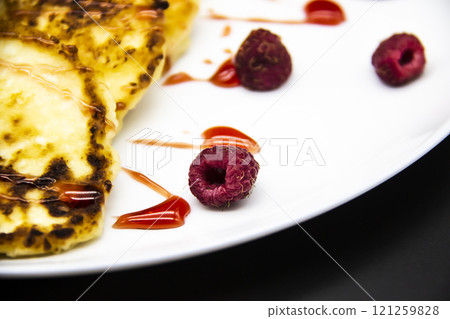 Ukrainian cottage cheese fritters, syrniki with jam on white plate. Cheese pancakes with raspberry without GMO. Delicious breakfast food at the morning. Ukrainian cottage cheese fritters, syrniki with jam on white plate. Cheese pancakes with raspberry without GMO. Delicious breakfast food at the morning. 121259828