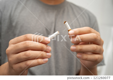 Quit smoking, Asian teenage man breaking destroy cigarette in hand. 121260077