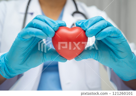 Asian woman doctor holding red heart for health in hospital. Asian woman doctor holding red heart for health in hospital. 121260101