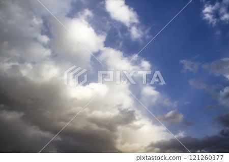 Clouds in the blue sky. A stunning gray sky. The storm is approaching. A beautiful clouds against the blue sky background. Amazing cloud pattern in the sky. 121260377