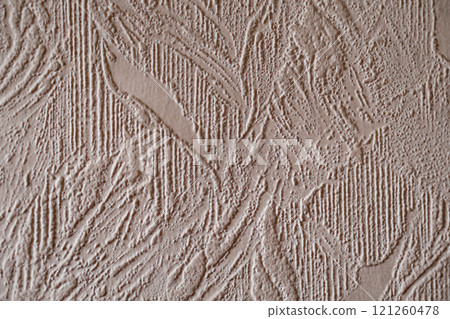 Wall surface with textured paper wallpaper of beige color, photographed at an angle. An example of how dust accumulates on such surfaces in the house, the need for cleaning 121260478