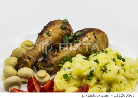Tasty cooked chicken legs with potatoes, tomatoes, mushrooms on a white plate. Delicious potatoes with onion and dill on dinner, lunch. Amazing chicken legs cooked in spice. Ukrainian healthy meal Tasty cooked chicken legs with potatoes, tomatoes, mushrooms on a white plate. Delicious potatoes with onion and dill on dinner, lunch. Amazing chicken legs cooked in spice. Ukrainian healthy meal 121260565
