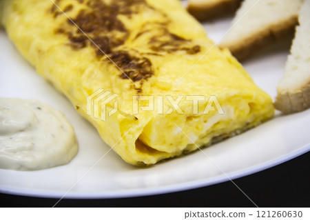 Amazing breakfast with tasty omelet, tomatoes, cheese, bread and sauce on the white plate. Delicious omelet made like rolle, other ingredients. Tasty and diet food. Healthy meal for breakfast or lunch Amazing breakfast with tasty omelet, tomatoes, cheese, bread and sauce on the white plate. Delicious omelet made like rolle, other ingredients. Tasty and diet food. Healthy meal for breakfast or lunch 121260630