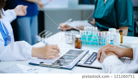 Medical team having a meeting with doctors in white lab coats and surgical scrubs seated Medical team having a meeting with doctors in white lab coats and surgical scrubs seated 121260751
