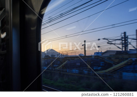 Mount Fuji silhouetted against sunset sky, view from Japanese shinkansen bullet train, Tokyo, Japan 121260881