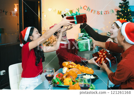 drinks and conversation, people celebrating together at Merry Christmas and Happy New Year. Friends are happy and celebrating with food, wine and friendship of love and gift exchange at the event. 121261168