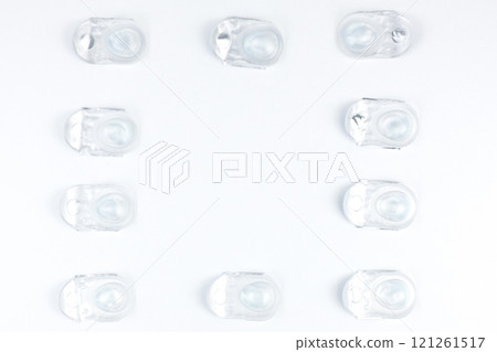 Disposable containers with lenses lying on a friend on a white background with space for text in the center. High quality photo 121261517