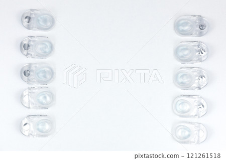 Daily contact lenses lie on the left and right of the photo in a row, with space for text on a white background. High quality photo Daily contact lenses lie on the left and right of the photo in a row, with space for text on a white background. High quality photo 121261518