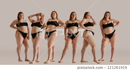 Same model in different poses. Young woman posing proudly in black underwear against neutral background, representing body positivity, and natural beauty. 121261919