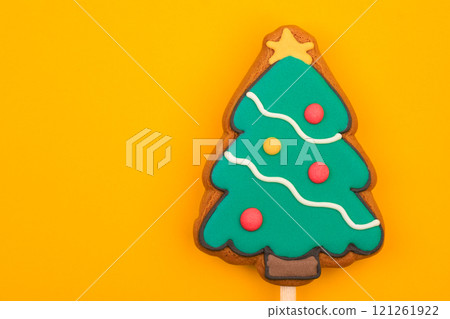 Christmas tree gingerbread cookie pop on yellow background Christmas tree gingerbread cookie pop on yellow background 121261922