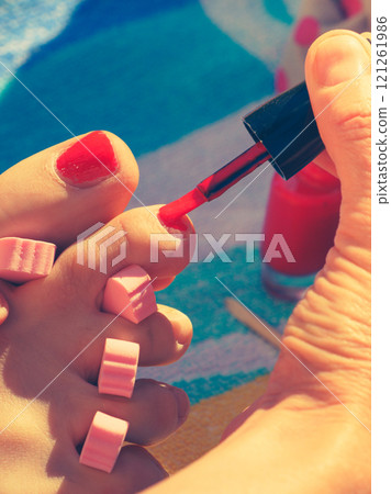Woman pedicure with red nail polish 121261986