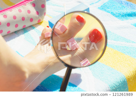 Woman magnifying pedicure Woman magnifying pedicure 121261989