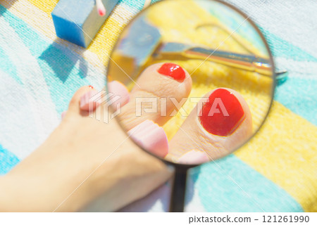 Woman magnifying pedicure Woman magnifying pedicure 121261990