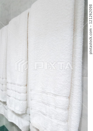 Close-up two clean white towels hanging on a rack 121262098