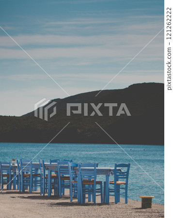 Open cafe outdoor restaurant in Greece on sea shore 121262222