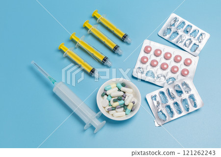 Empty and used medicine blister packs with pink pills and syringes. Empty and used medicine blister packs with pink pills and syringes. 121262243