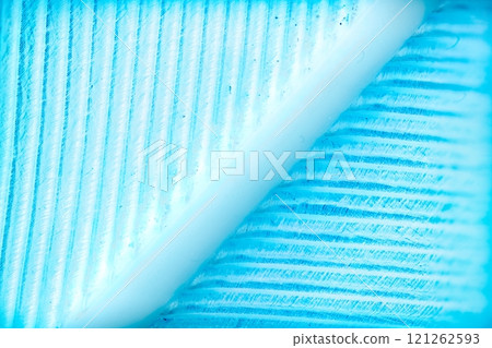 A macro photograph showcasing the intricate texture of a blue feather, revealing fine barbs and a central rachis 121262593