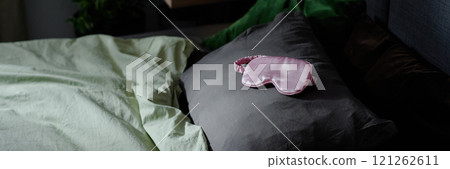 Website banner with silk pink rose sleep mask on grey pillow 121262611