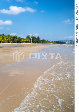 Experience a Serene Beach View With Gentle Waves Lapping Against The Shore and a Clear Sky 121262813