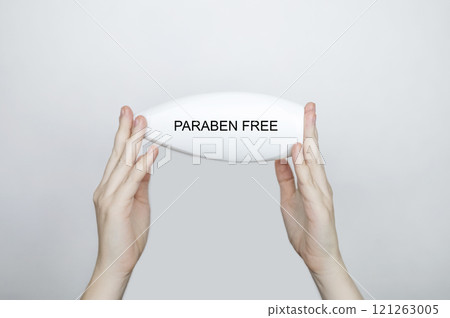 Female hands holding a can of shampoo, where it is written paraben free, no paraben. The concept of safe composition of shampoo without aggressive components Female hands holding a can of shampoo, where it is written paraben free, no paraben. The concept of safe composition of shampoo without aggressive components 121263005