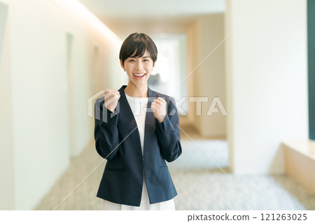 A woman in a suit that makes a guts pose 121263025