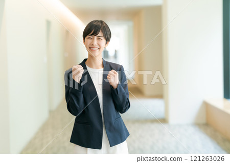 A woman in a suit that makes a guts pose 121263026
