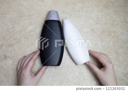 Female hands holding a can of shampoo with a blank label. White background, space for text. Composition of shampoo or conditioner Female hands holding a can of shampoo with a blank label. White background, space for text. Composition of shampoo or conditioner 121263032