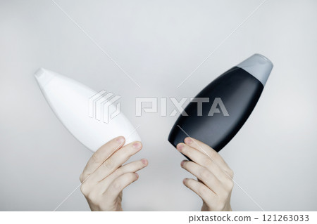 Female hands holding a can of shampoo with a blank label. White background, space for text. Composition of shampoo or conditioner Female hands holding a can of shampoo with a blank label. White background, space for text. Composition of shampoo or conditioner 121263033