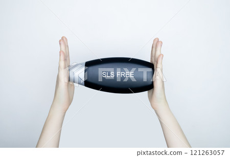 Female hands holding a can of shampoo, where it is written no sls, sls free. The concept of safe composition of shampoo without aggressive components Female hands holding a can of shampoo, where it is written no sls, sls free. The concept of safe composition of shampoo without aggressive components 121263057