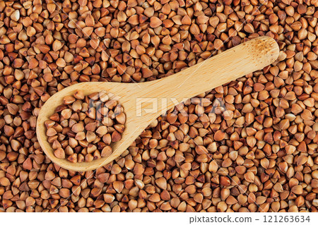 Raw buckwheat in wooden spoon as a background. Top view. Flat lay 121263634